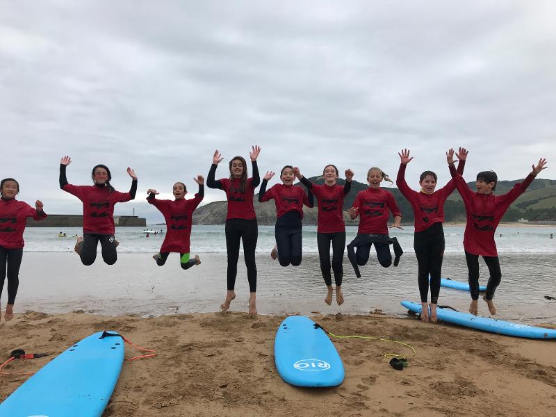 Niños haciendo surf en el campamento de Santander
